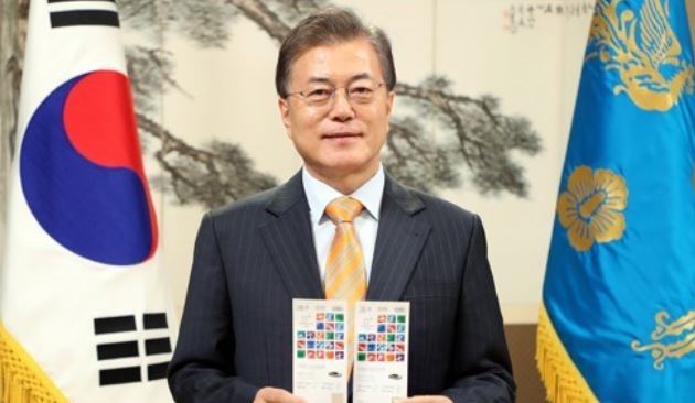 The captured image from an event site of the PyeongChang Winter Olympic Games shows President Moon Jae-in holding up tickets to the games in a photo posted by his office Cheong Wa Dae on Nov. 26, 2017 as part of efforts to promote the Winter Olympic Games that will be held in South Korea's Pyeongchang in February 2018. (Yonhap)