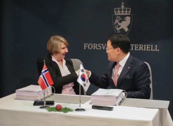 Son Jae-il, CEO of Hanwha Land Systems, shakes hands with Mette Elin Sørfonden, head of Norway's defense material agency, after a contract on K9 self-propelled howitzers in this photo provided by the firm. (Yonhap)