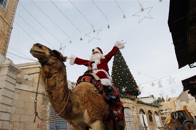 <YONHAP PHOTO-1861> (171221) -- JERUSALEM, Dec. 21, 2017 (Xinhua) -- A man dressed as Santa Claus rides a camel in Jerusalem's Old City, on Dec. 21, 2017. (Xinhua/Muammar Awad)/2017-12-22 09:00:11/ <저작권자 ⓒ 1980-2017 ㈜연합뉴스. 무단 전재 재배포 금지.>