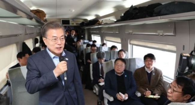 The photo, taken Dec. 19, 2017, shows President Moon Jae-in (L) speaking in a press conference held on a KTX bullet train to Pyeongchang, the host city of the 2018 Winter Olympic Games that is located some 180 kilometers east of Seoul. (Yonhap)