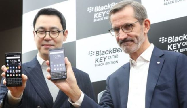 Alain Lejeune (R), president of BlackBerry Mobile, and Shin Jai-sik, head of the firm's South Korean arm, pose for a photo with the BlackBerry KEYone Black Edition during a press conference in Seoul on Dec. 22, 2017. (Yonhap)