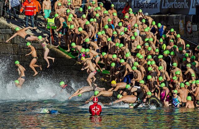 <YONHAP PHOTO-0020> epaselect epa06405468 Swimmers jump into the water at the start of the Christmas Crossing 2017 in Gijon, Spain, 25 December 2017. Every year, swimmers attend the race at the city's port covering a distance of 220 meters to try to win Spain's second oldest Christmas swimming competition. EPA/Alberto Morante/2017-12-26 00:10:24/ <저작권자 ⓒ 1980-2017 ㈜연합뉴스. 무단 전재 재배포 금지.>