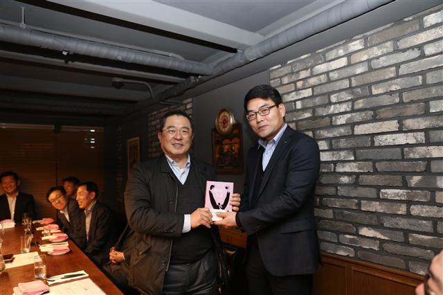구자열 LS그룹 회장(왼쪽)이 LS전선 부스덕트 사업부 김우태 이사에게 ‘불타는 투혼’ 책을 선물하고 있다.  [제공=LS그룹]