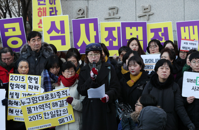 A group of activists address the 2015 "comfort women" agreement outside the Central Government Complex in Seoul on Wednesday. (Yonhap)
