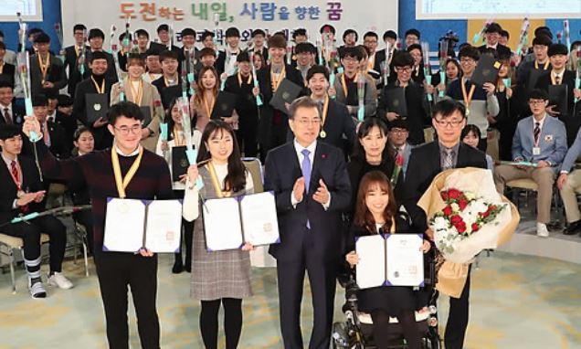 President Moon Jae-in (front row, third from L) poses for a group photo after presenting certificates of scholarship to students in a meeting held at his office Cheong Wa Dae in Seoul on Dec. 28, 2017. (Yonhap)