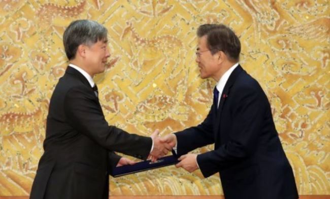 President Moon Jae-in (R) shakes hands with the new head of the Board of Audit and Inspection, Choe Jae-hyeong, after presenting him with a certificate of appointment in a ceremony held at his office Cheong Wa Dae on Jan. 2, 2018. (Yonhap)