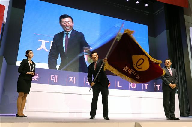 롯데가 그동안 말이 많았던 순환출자를 해소하면서 투명경영의 단초를 마련했다. ‘신동빈의 뉴롯데’ 출발점이기도 하다. 지난해 롯데지주 출범식에서 신동빈 롯데 회장이 깃발을 들어보이고 있다.