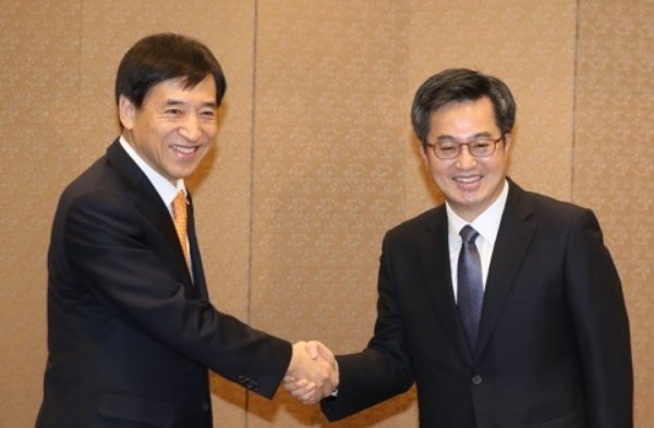 Bank of Korea Gov. Lee Ju-yeol (L) and Finance Minister Kim Dong-yeon shake hands at a breakfast meeting in Seoul on Jan. 4, 2018. (Yonhap)