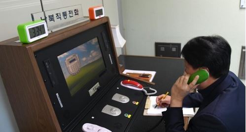 This photo, provided by South Korea's unification ministry on Jan. 3, 2018, shows a liaison official talking with his North Korean counterpart via the reopened inter-Korean hotline at the truce village of Panmunjom. (Yonhap)