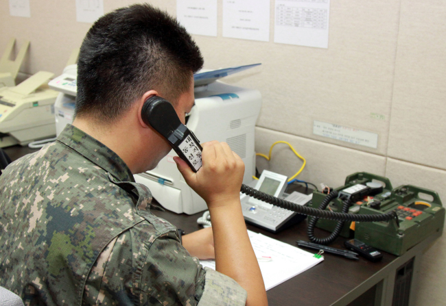 A South Korean soldier performs test-calls on the inter-Korean military hotline near the West Sea region in July 2017. (Yonhap)