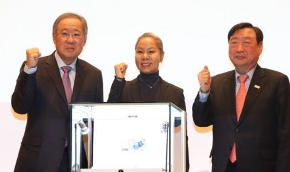 Poongsan Group Chairman Ryu Jin, singer Insooni and POCOG President Lee Hee-beom (from L to R) pose for photos behind a new deluxe coin set commemorating the 2018 PyeongChang Winer Olympics on Jan. 10, 2018 at Poongsan's headquarters in central Seoul. The set is priced at 11 million won and will go on preorder starting Jan. 15, 2018. (Yonhap)