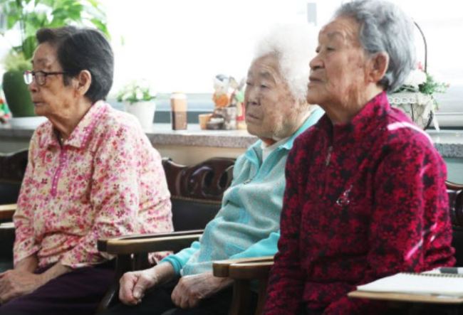 Former comfort women at their shelter in Gwangju, east of Seoul, on Jan. 10, 2018, watch President Moon Jae-in deliver his New Year's speech via TV.