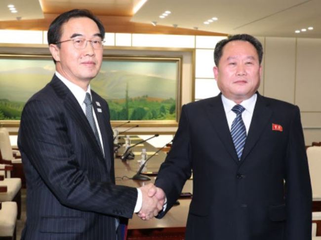 South Korean Unification Minister Cho Myoung-gyon (left) exchanges a joint press statement with the head of North Korean delegation Ri Son-gwon at their meeting at the Panmunjeom in the DMZ in Paju, South Korea, Tuesday, Jan. 9, 2018. (Yonhap)
