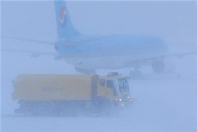 <YONHAP PHOTO-1808> 제주국제공항 제설 한창 (제주=연합뉴스) 박지호 기자 = 폭설이 쏟아진 11일 오전 제설차량이 제주국제공항 활주로에서 눈을 치우고 있다. 2018.1.11 jihopark@yna.co.kr/2018-01-11 09:23:41/ <저작권자 ⓒ 1980-2018 ㈜연합뉴스. 무단 전재 재배포 금지.>