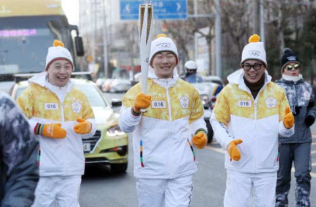 K-pop hip-hop group Rhythm Power carries the torch for the 2018 PyeongChang Winter Olympics in the city of Incheon, west of Seoul, on Jan. 11, 2018. (Yonhap)