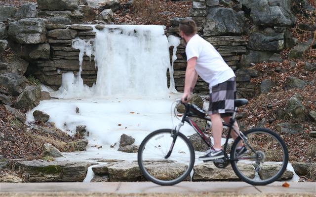 <YONHAP PHOTO-3025> A bicyclist in shorts, slows to look at the frozen Cascades waterfall in Forest Park while temperatures hover near 70 degrees in St. Louis on January 11, 2018. Temperatures have remained below freezing for two weeks but have risen slightly the last couple of days. Forcasters predict temperatures will drop to the teens before today is over. Photo by Bill Greenblatt/UPI/2018-01-12 07:23:08/ <저작권자 ⓒ 1980-2018 ㈜연합뉴스. 무단 전재 재배포 금지.>