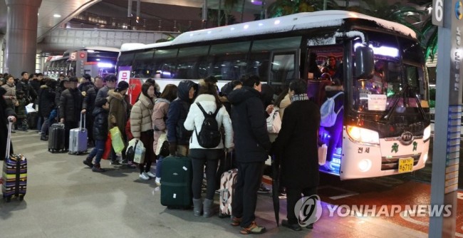 강풍과 폭설로 항공편이 무더기로 결항해 제주공항에서 발이 묶인 관광객들이 11일 밤늦게 숙소로 가기 위해 제주도가 마련한 무료 셔틀버스에 타고 있다. (사진=연합뉴스)