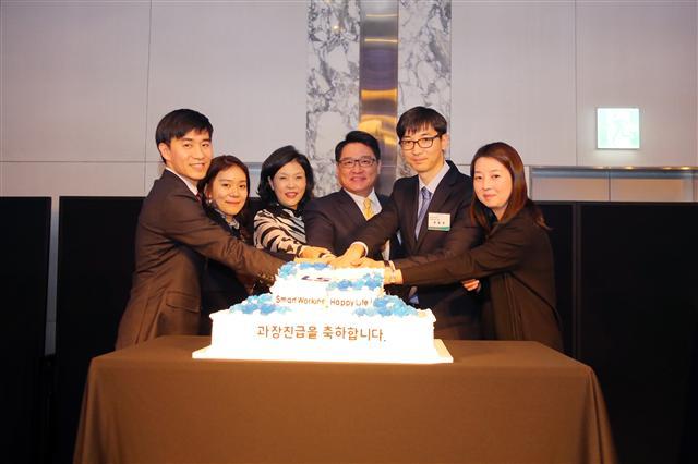 LS산전 CEO 구자균 회장 부부(가운데)가 과장 진급을 함께 축하하는 ‘Smart Workin
g, Happy Life’ 행사에서 과장부부와 함께 축하 케이크를 자르고 있다.  [제공=LS산전]