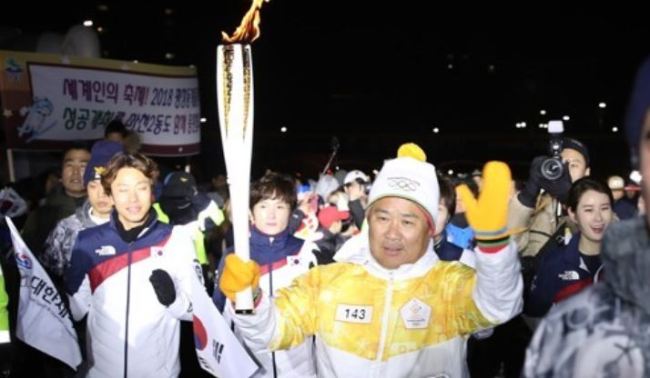Korean Olympic & Sport Committee President Lee Kee-heung carries a torch for the 2018 PyeongChang Olympic Games, in Seoul on Jan. 14, 2018. (Yonhap)