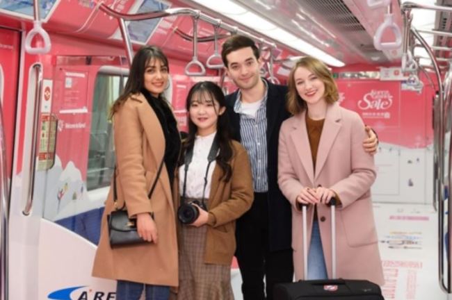 In this undated photo, provided by the Visit Korea Committee, tourists pose on a train promoting the Korea Grand Sale 2018, which will kick off nationwide on Jan. 18, 2018, for a 42-day run. (Yonhap)