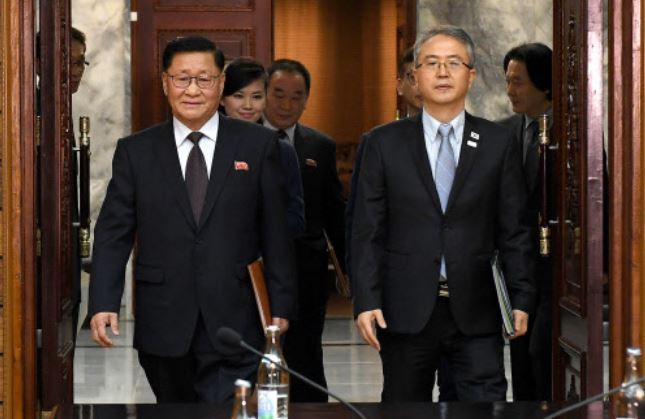 Kwon Hyok-bong,  director of the performing arts bureau at the culture ministry and the North‘s chief delegate, left, and Lee Woo-sung, a senior official at the Seoul‘s culture ministry and the South‘s chief delegate, step into a meeting room in Tongilgagk in the northern side of Panmunjeom, for a working-level talks on Monday. (Yonhap)