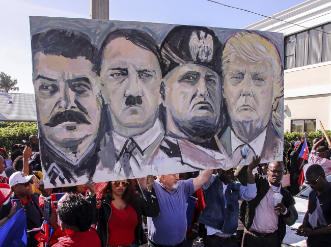 <YONHAP PHOTO-1437> Haitian community members hold an image depicting image shows from left, Joseph Stalin, Adolf Hitler, Benito Mussolini and President Donald Trump during a protest near Trump's Mar-a-Lago estate Monday, Jan. 15, 2018, in West Palm Beach, Fla. Trump is defending himself anew against accusations that he is racist, this time after recent disparaging comments about Haiti and African nations. The group said they were there to demand an apology from the Trump. (Damon Higgins/Palm Beach Post via AP)/2018-01-16 07:19:08/ <저작권자 ⓒ 1980-2018 ㈜연합뉴스. 무단 전재 재배포 금지.>
<YONHAP PHOTO-1437> Haitian community members hold an image depicting image shows from left, Joseph Stalin, Adolf Hitler, Benito Mussolini and President Donald Trump during a protest near Trump's Mar-a-Lago estate Monday, Jan. 15, 2018, in West Palm Beach, Fla. Trump is defending himself anew against accusations that he is racist, this time after recent disparaging comments about Haiti and African nations. The group said they were there to demand an apology from the Trump. (Damon Higgins/Palm Beach Post via AP)/2018-01-16 07:19:08/ <저작권자 ⓒ 1980-2018 ㈜연합뉴스. 무단 전재 재배포 금지.>