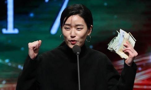 In this file photo, singer-songwriter Lee Lang celebrates on stage at the Korean Music Awards on Feb. 28, 2017, in Seoul after selling the trophy for her Best Folk Song award to an audience. (Yonhap)