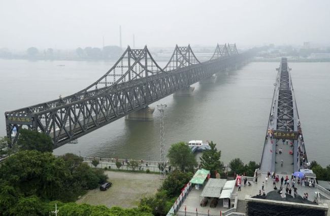 In this Sept. 9, 2017, file photo, visitors walk across the Yalu River Broken Bridge, right, next to the Friendship Bridge connecting China and North Korea in Dandong in northeastern China’s Liaoning province. (AP)