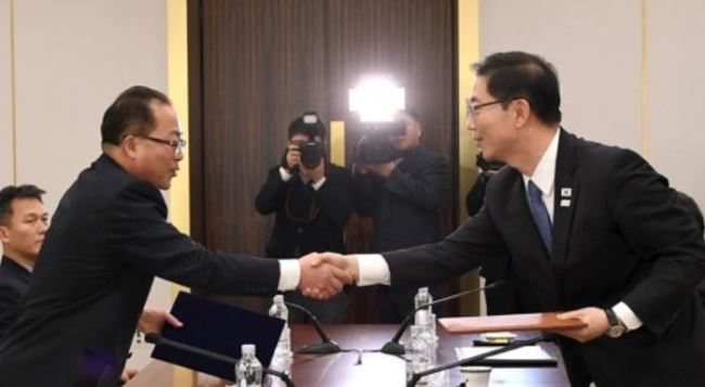South Korean and North Korean chief delegates shake hands after agreeing at talks on Jan. 17, 2018, to march together under a unified flag at the opening ceremony of the PyeongChang Olympics. (Yonhap)