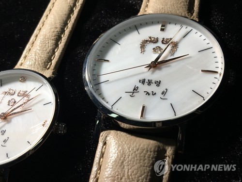 문재인 대통령의 이름이 새겨진 손목시계가 나왔다. 이 시계는 뒷면에 '사람이 먼저다'란 글귀가 쓰여 있고 앞면 시계 앞면에는 봉황 마크와 '대통령 문재인'이라고 쓰여 있다. 남성용과 여성용. 2017.8.10 (사진=연합뉴스)