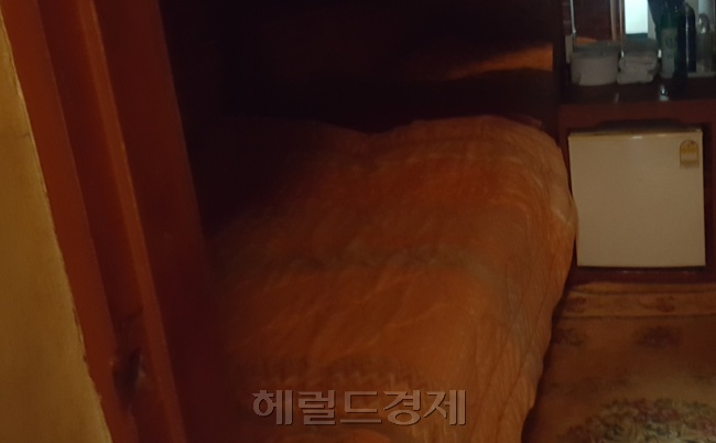 지난 20일 화재가 난 종로 여관 근처의 한 여관. 장기투숙방이 있다는 광고가 붙여있다(맨 위 사진). 인근 여관의 객실 모습. 2평 남짓한 방에 침대 하나와 냉장고가 놓여있다(왼쪽 아래 사진). 화재가 난 서울장 여관의 모습(아래 오른쪽 사진).