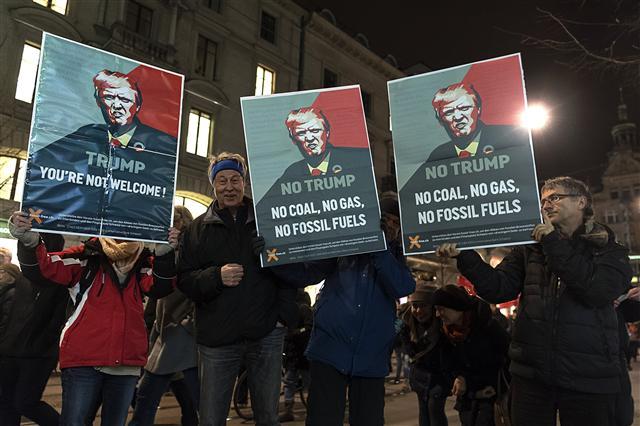 <YONHAP PHOTO-2478> epa06468572 Protesters are holding posters with Donald Trump's portrait saying 'You're not welcome' during the demonstration 'Trump not welcome!' against the upcoming visit of US President Donald Trump at the World Economic Forum (WEF) in Davos, in the streets of Zurich, Switzerland, 23 January 2018. EPA/WALTER BIERI/2018-01-24 06:00:46/ <저작권자 ⓒ 1980-2018 ㈜연합뉴스. 무단 전재 재배포 금지.>