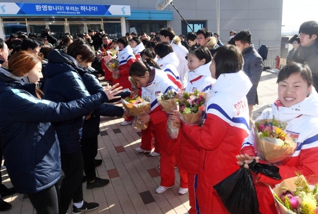 Members of the South Korean women's ice hockey team welcome their North Korean teammates with a bouquet of flowers as they arrive at a center to conduct a joint exercise, in Jincheon, North Cungcheong Province, Thursday. (Yonhap)