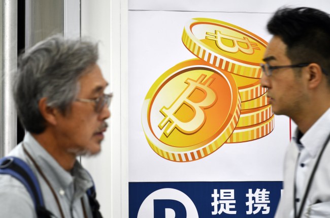 Pedestrians walk past a Bitcoin currency poster at the entrance of an electronics retailers store in central Tokyo, Japan, 01 June 2017. (EPA-Yonhap)