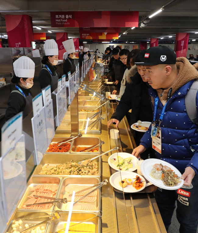 IN LINE FOR FOOD -- Press corps covering the PyeongChang Olympics wait in line for food at a dining facility at Gangneung Media Village in Gangwon Province on Sunday. Yonhap