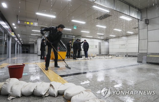 Workers mop up at Express Bus Terminal Station on Line No. 9, southern Seoul, Monday morning. (Yonhap)
