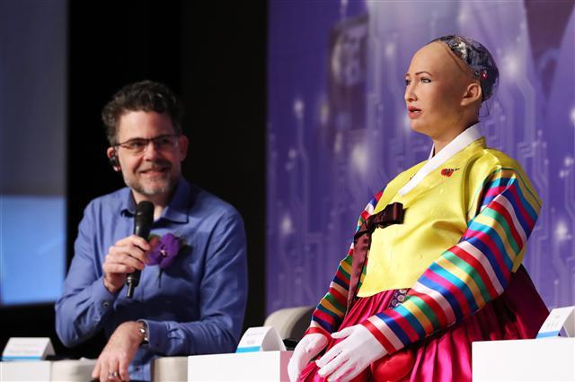 <YONHAP PHOTO-1524> 인공지능 '소피아' 연설 지켜보는 데이비드 핸슨 (서울=연합뉴스) 김주형 기자 = 인공지능(AI)로봇 '소피아'가 30일 오전 서울 중구 더프라자호텔 그랜드볼룸에서 열린 '4차 산업혁명, 소피아에게 묻다' 콘퍼런스에서 '로봇의 기본 권리'에 대해 연설하고 있다. 왼쪽은 핸슨 로보틱스의 데이비드 핸슨 CEO. 2018.1.30 kjhpress@yna.co.kr/2018-01-30 10:31:09/ <저작권자 ⓒ 1980-2018 ㈜연합뉴스. 무단 전재 재배포 금지.>