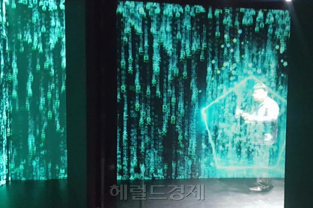 마치 영화 매트릭스 같은 ‘차원의 벽’을 통과하는 모습(왼쪽)  5G 커넥티드 안에 마련된 미래도시 모형  [헤럴드경제]