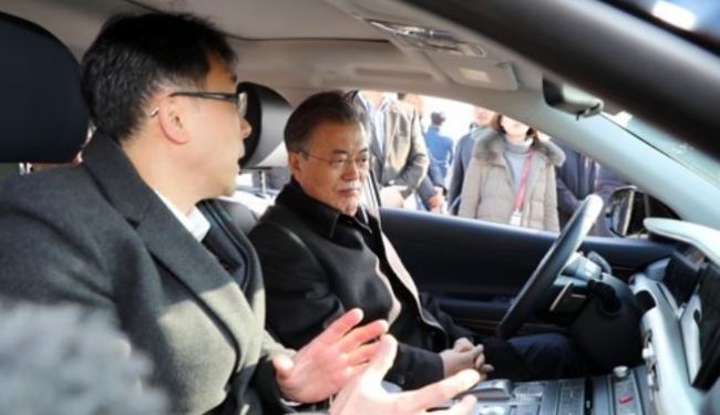 President Moon Jae-in (R) listens to an official from Hyundai Motor Co. explain how to operate a self-driving car before embarking on a 15-minute test drive in the autonomous fuel cell vehicle on a highway just outside of Seoul on Feb. 2, 2018. (Yonhap)