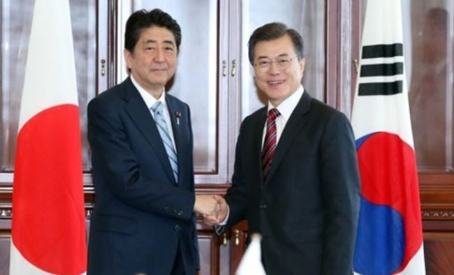 South Korean President Moon Jae-in (R) shakes hands with Japanese Prime Minister Shinzo Abe before the start of their bilateral summit on the sidelines of the Eastern Economic Forum in Vladivostok, Russia, on Sept. 7, 2017. (Yonhap)
