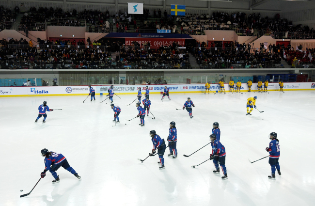 Korean ice hockey players waarm up ahead of a friendly match against Swedish players, Feb. 4, 2018. (Yonhap)