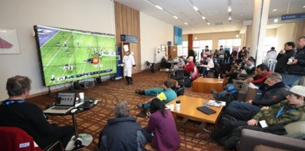 International journalists and Olympic officials gather around the big screen at the Main Press Centre for the PyeongChang Winter Olympics in PyeongChang, Gangwon Province, to watch the Super Bowl LII between the New England Patriots and the Philadelphia Eagles, on Feb. 5, 2018. (Yonhap)