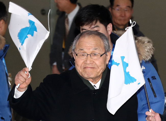 Waving a Korean Unification flag, Pae Ik-ju, leader of a cheering group from the pro-Pyongyang General Association of Korean Residents in Japan, known as Chongryon, arrives at Seoul's Gimpo airport on Feb. 8, 2018. (Yonhap)