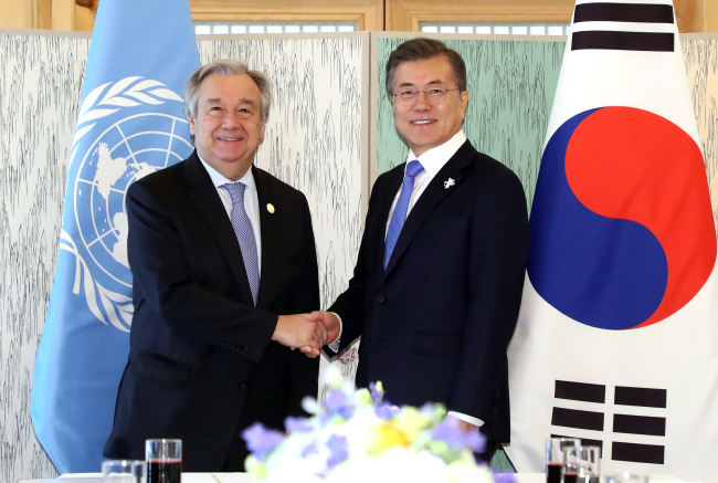 President Moon Jae-in (R) and UN Secretary General Antonio Guterres shake hands before holding a meeting over lunch in Gangneung, 230 kilometers east of Seoul, on Friday. (Yonhap)