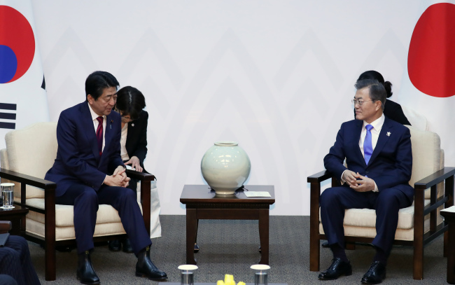 South Korean President Moon Jae-in (R) and Japanese Prime Minister Shinzo Abe hold a bilateral summit in South Korea's eastern city of Yongpyeong, located 200 kilometers from Seoul, on Friday. (Yonhap)