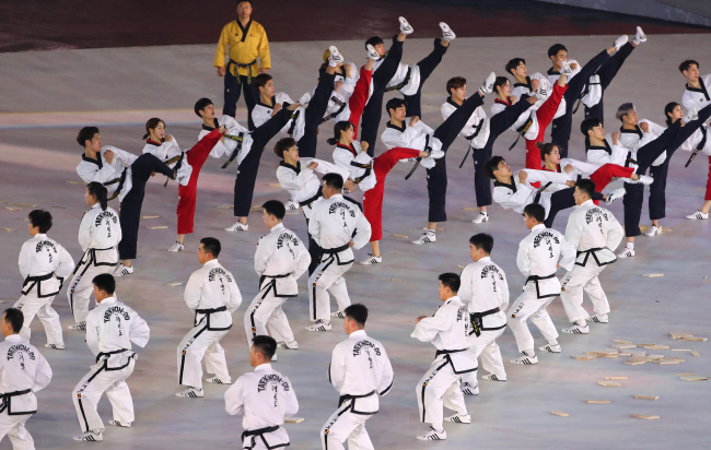 Taekwondo practitioners from South Korea and North Korea perform together at the Olympic Stadium in PyeongChang, Gangwon Province, ahead of the opening ceremony for the PyeongChang Winter Olympics on Friday. (Yonhap)