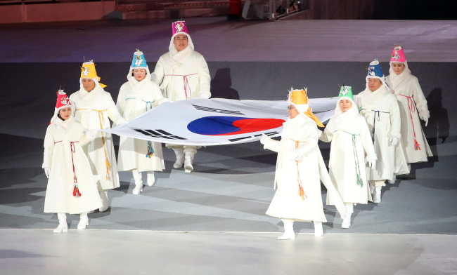 Former South Korean Olympians and Olympic gold medalists carry the national flag into PyeongChang Olympic Stadium during the opening ceremony of the 2018 PyeongChang Winter Olympics on Feb. 9, 2018. (Yonhap)