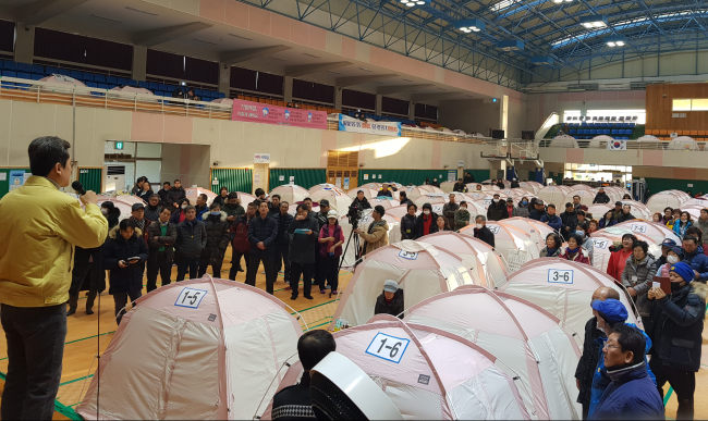 Pohang city mayor Lee Kang-deok (L) explains actions being taken to residents gathered at an emergency shelter following the 4.6 tremor on Feb. 11, 2018. (Yonhap)