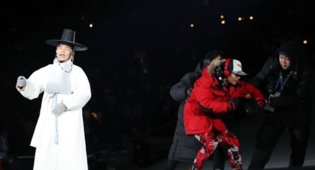 In this file photo, an unidentified intruder (2nd from R) is wrestled off stage by security officials at the opening ceremony of the PyeongChang Winter Olympics in PyeongChang on Feb. 11, 2018. (Yonhap)