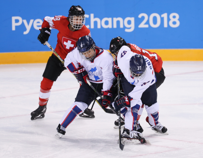 Korean players Kim Se-lin (2nd from L) and Randi Heesoo Griffin (R) keep a Swiss player in check during the teams' Group B game of the women's ice hockey tournament at the PyeongChang Winter Olympics in Gangneung, Gangwon Province, on Feb. 10, 2018. (Yonhap)